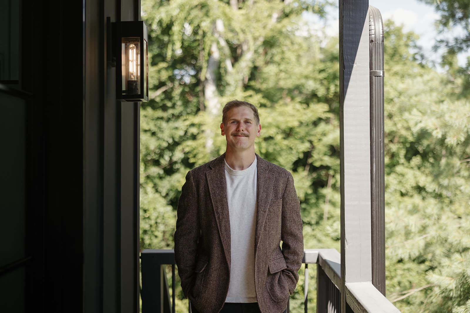 Ryan Boggs standing on a covered porch surrounded by trees