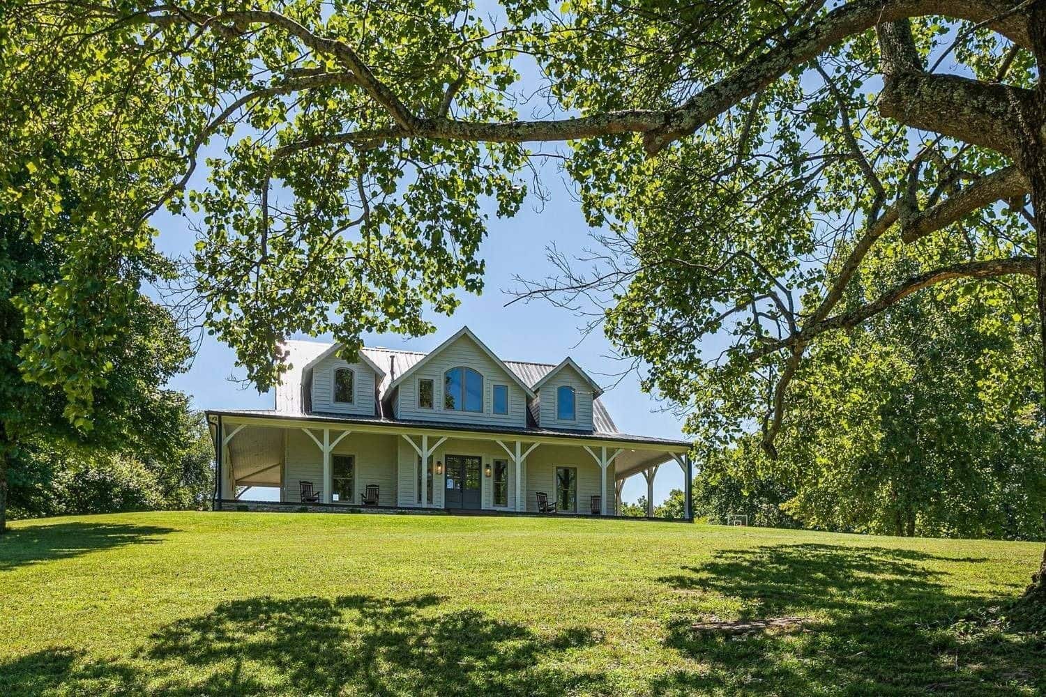 White farmhouse estate framed by mature trees on Williamson County acreage