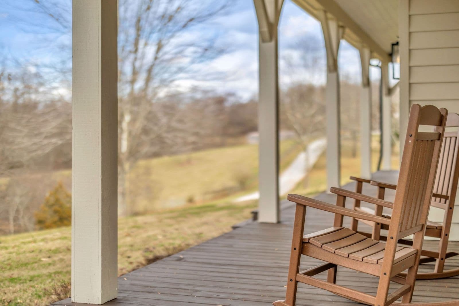Rocking chairs on a farmhouse porch overlooking Thompson's Station countryside