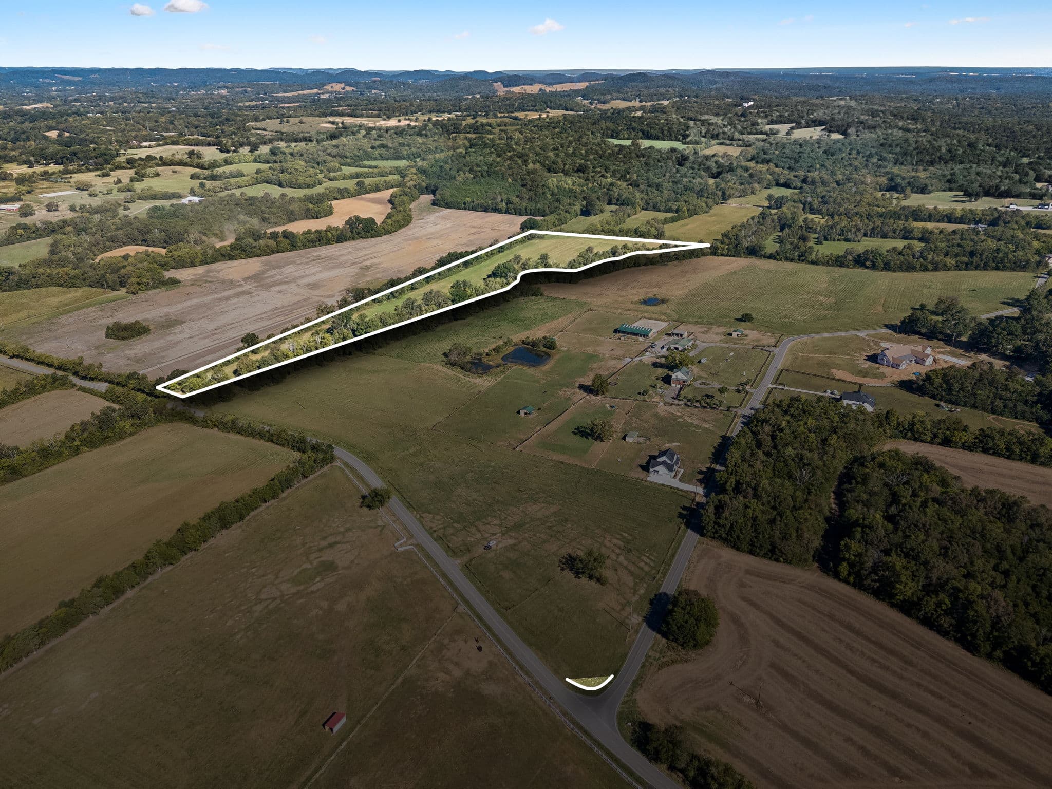 Aerial view of Tract 1 in College Grove, TN, outlined in white: a narrow wooded strip along the tree line