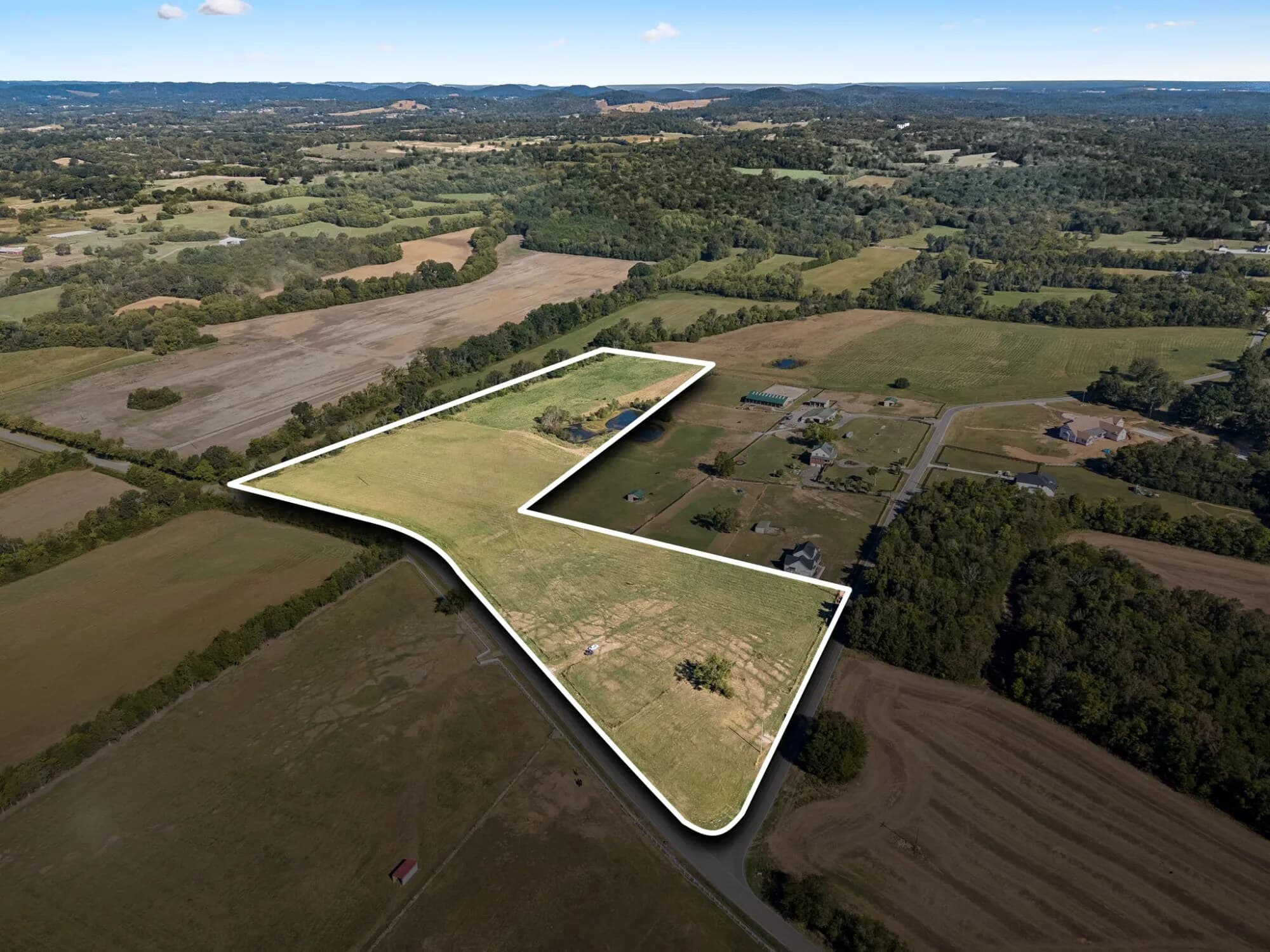Aerial view of Tract 3 in College Grove, TN, outlined in white: the corner field along Patterson and Rehobath Roads, with its line running through the shared pond
