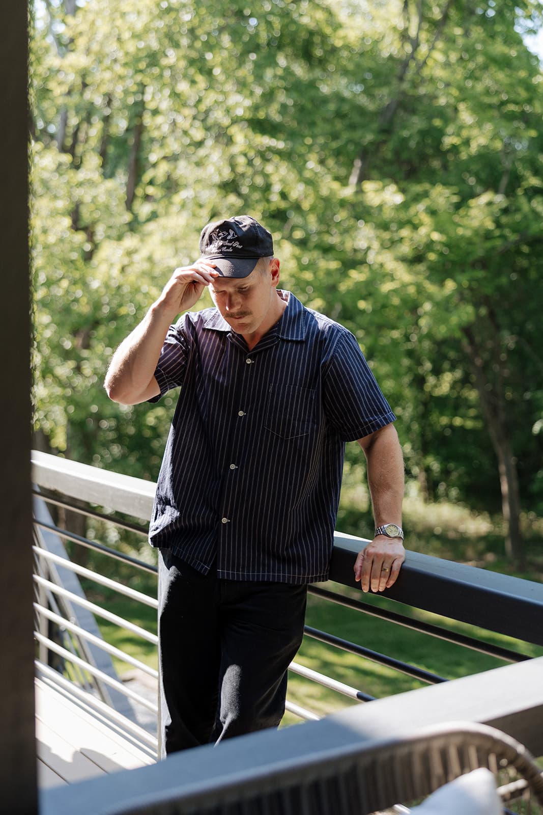 Ryan Boggs adjusting his cap on an outdoor deck