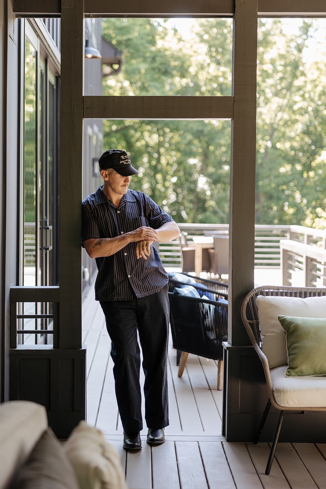 Ryan Boggs standing in a screened porch doorway, arms crossed